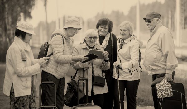group-of-positive-senior-elderly-people-looking-at-digital-map-on-traveling-journey_NB-scaled